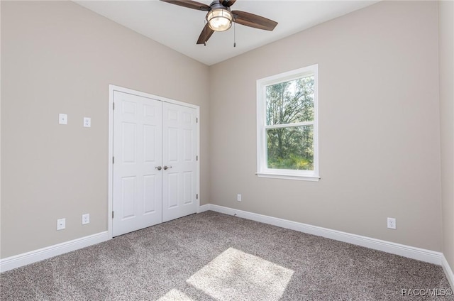 unfurnished bedroom featuring a closet, carpet flooring, a ceiling fan, and baseboards