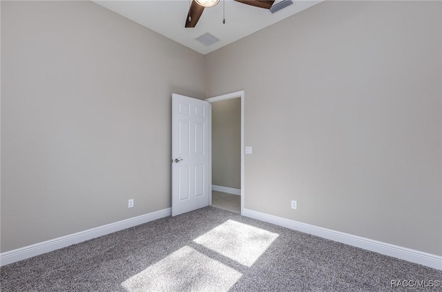 carpeted empty room featuring visible vents, baseboards, and ceiling fan