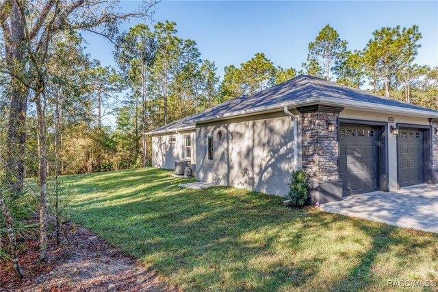 view of side of home with concrete driveway and a yard