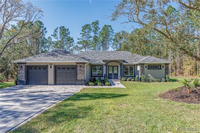 single story home featuring a front yard, driveway, an attached garage, stucco siding, and stone siding