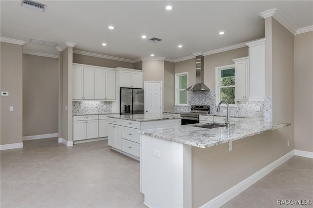 kitchen with visible vents, a sink, stainless steel appliances, wall chimney range hood, and baseboards