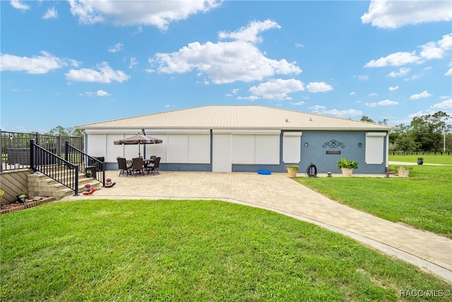 exterior space with a garage, a patio area, and a yard