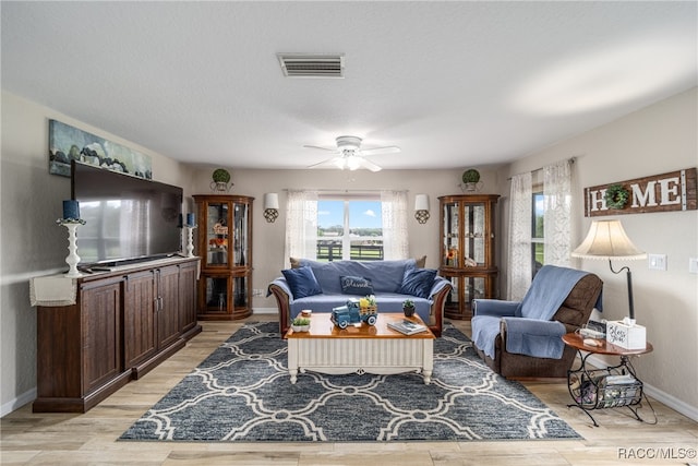 living room with ceiling fan and light hardwood / wood-style flooring