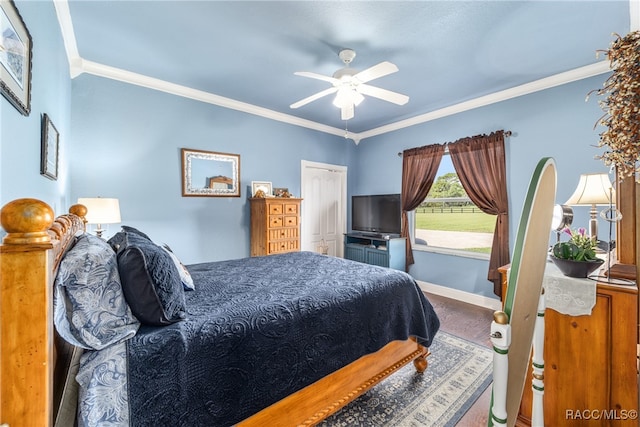 carpeted bedroom with ceiling fan, ornamental molding, and a closet