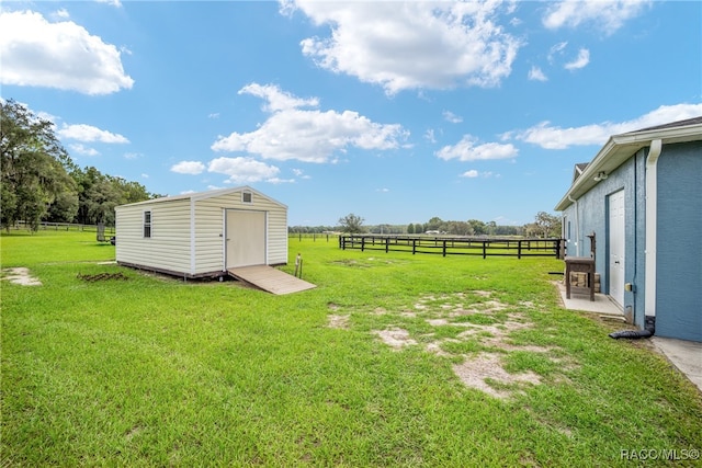 view of yard with a rural view and a shed