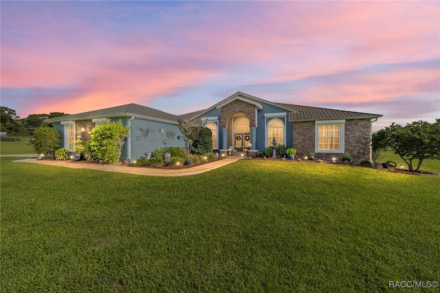 ranch-style home featuring a lawn