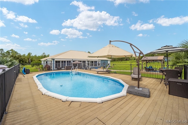 view of swimming pool featuring a gazebo, a wooden deck, and a lawn