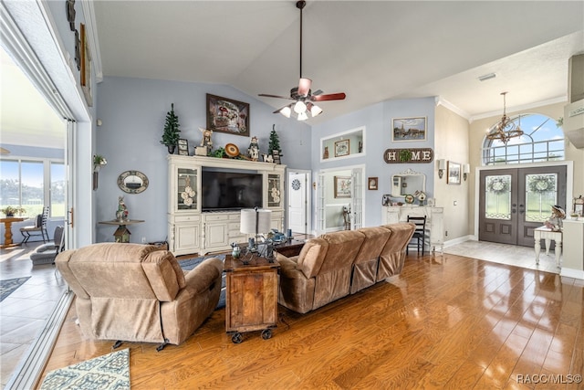 living room with ornamental molding, french doors, a healthy amount of sunlight, and light hardwood / wood-style flooring