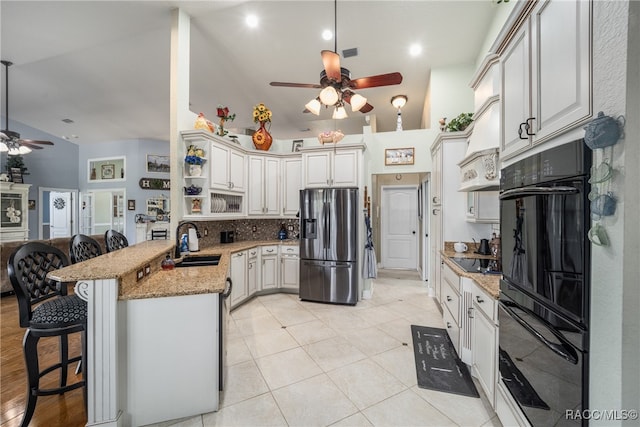 kitchen featuring white cabinetry, sink, a kitchen breakfast bar, kitchen peninsula, and black appliances