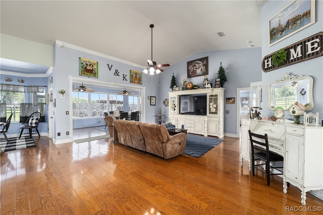 living room featuring hardwood / wood-style floors, ceiling fan, lofted ceiling, and crown molding