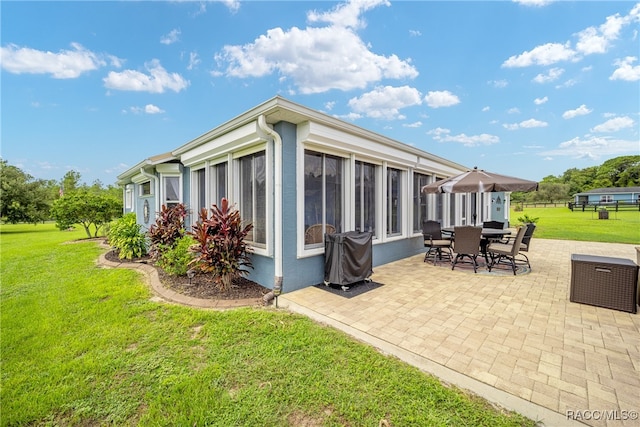 back of property with a patio and a lawn