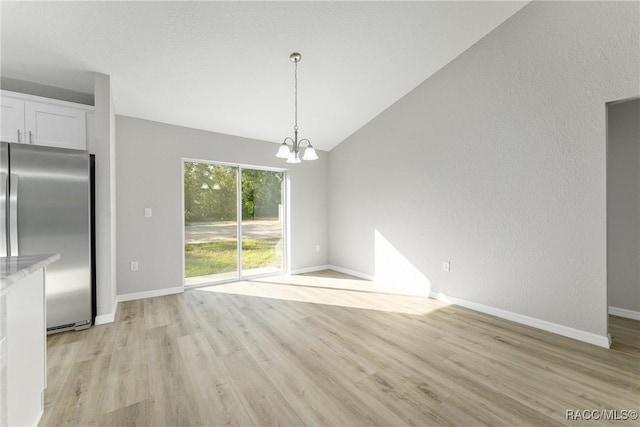 9065 N Arcadia Way, Citrus Springs, FL 34434 - unfurnished dining area featuring light wood-type flooring, baseboards, lofted ceiling, and a notable chandelier