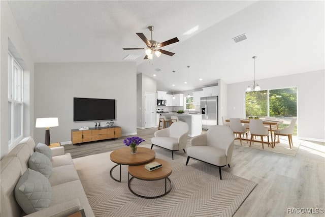 9065 N Arcadia Way, Citrus Springs, FL 34434 - living room with lofted ceiling, ceiling fan with notable chandelier, visible vents, and light wood-style floors