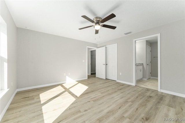 9065 N Arcadia Way, Citrus Springs, FL 34434 - unfurnished bedroom with connected bathroom, light wood-type flooring, visible vents, baseboards, and ceiling fan