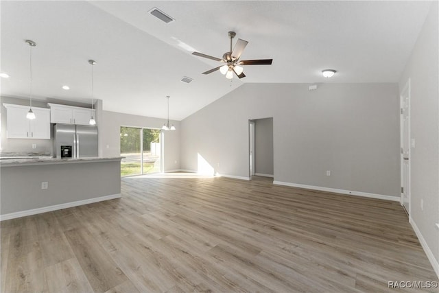 9065 N Arcadia Way, Citrus Springs, FL 34434 - unfurnished living room with light wood finished floors, lofted ceiling, ceiling fan with notable chandelier, and visible vents