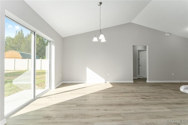 9065 N Arcadia Way, Citrus Springs, FL 34434 - unfurnished dining area with light wood-type flooring, vaulted ceiling, baseboards, and a notable chandelier