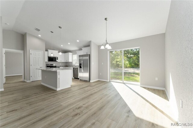 9065 N Arcadia Way, Citrus Springs, FL 34434 - kitchen featuring stainless steel appliances, visible vents, vaulted ceiling, a chandelier, and a center island