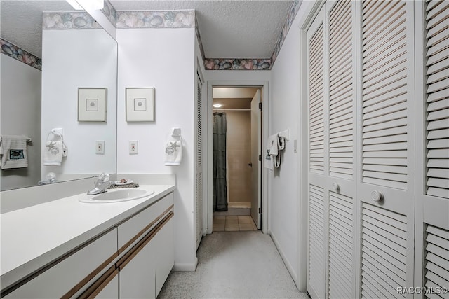 bathroom with vanity, a textured ceiling, and curtained shower