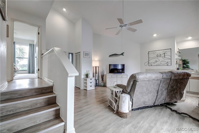 living room featuring light wood-type flooring, high vaulted ceiling, and ceiling fan