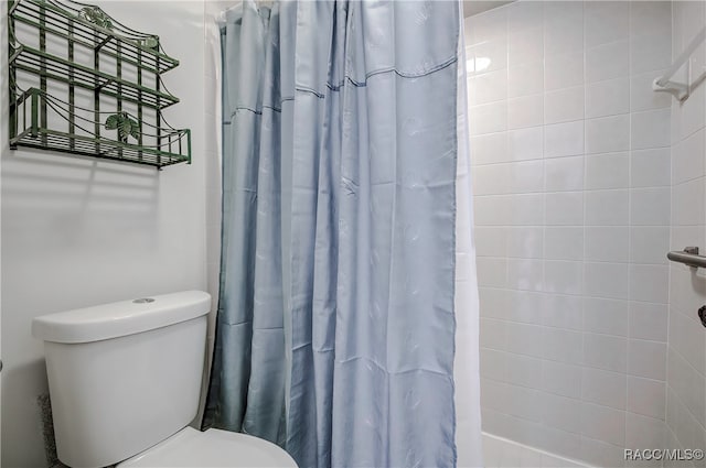 bathroom featuring a shower with shower curtain and toilet