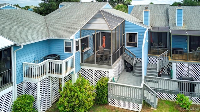 rear view of property featuring central AC unit and a wooden deck