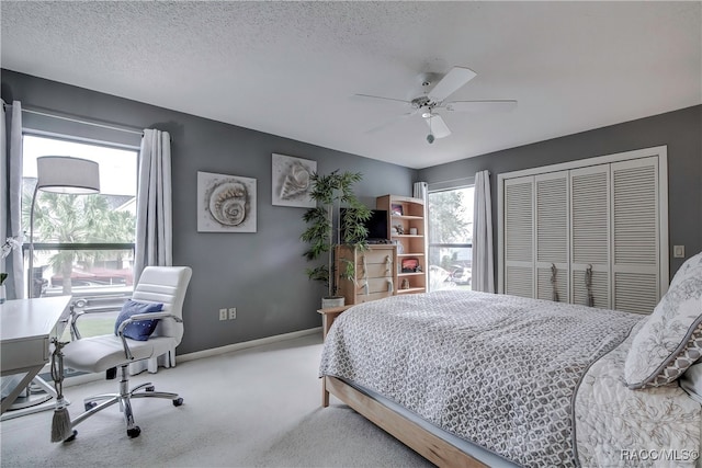 bedroom featuring multiple windows, ceiling fan, a closet, and carpet floors