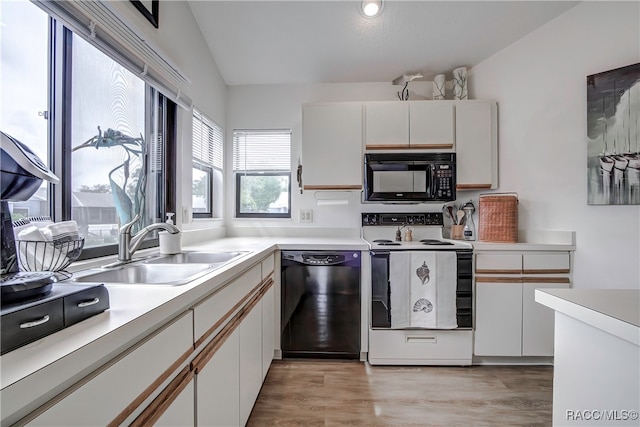 kitchen with sink, black appliances, light hardwood / wood-style flooring, white cabinets, and lofted ceiling