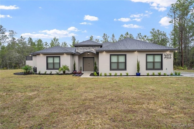 prairie-style house with central air condition unit, stone siding, and a front yard