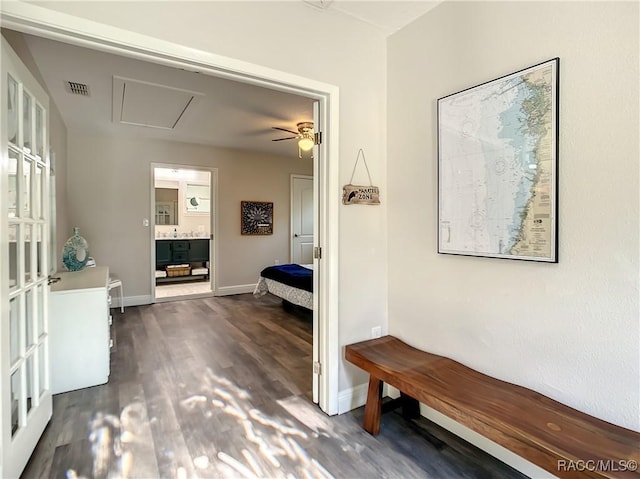 hallway with dark wood-style floors, visible vents, and baseboards