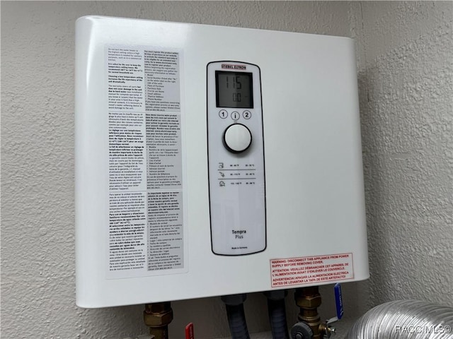 room details with water heater and a textured wall