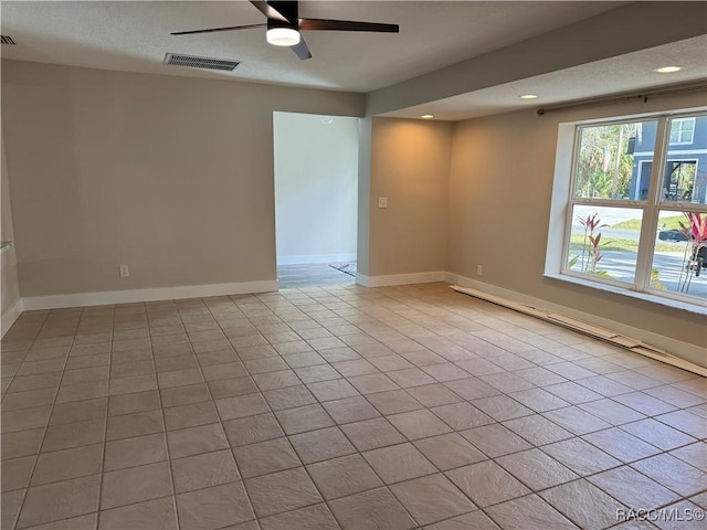 empty room with light tile patterned floors, recessed lighting, a ceiling fan, visible vents, and baseboards