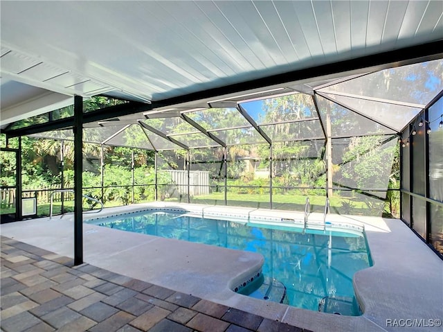 pool with glass enclosure and a patio