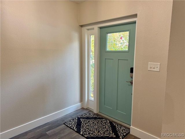 entryway featuring baseboards and dark wood-type flooring