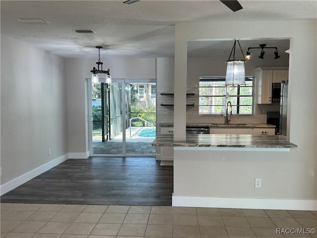 kitchen with white cabinetry, a sink, and decorative light fixtures