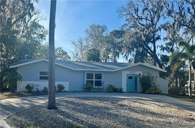 ranch-style house with concrete driveway and brick siding