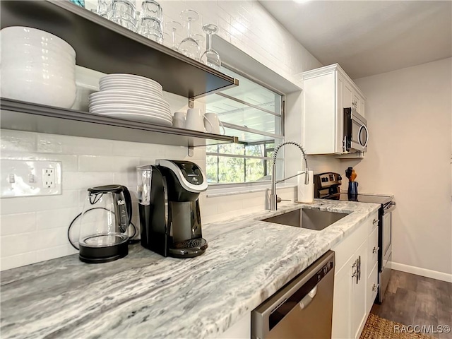 kitchen featuring appliances with stainless steel finishes, sink, white cabinets, and light stone counters