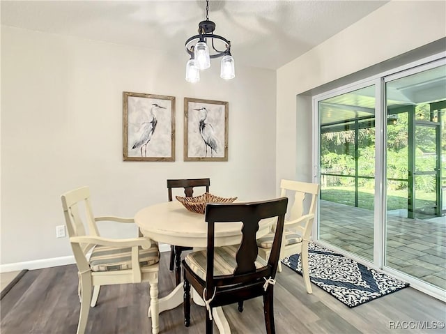 dining space with wood-type flooring and a chandelier