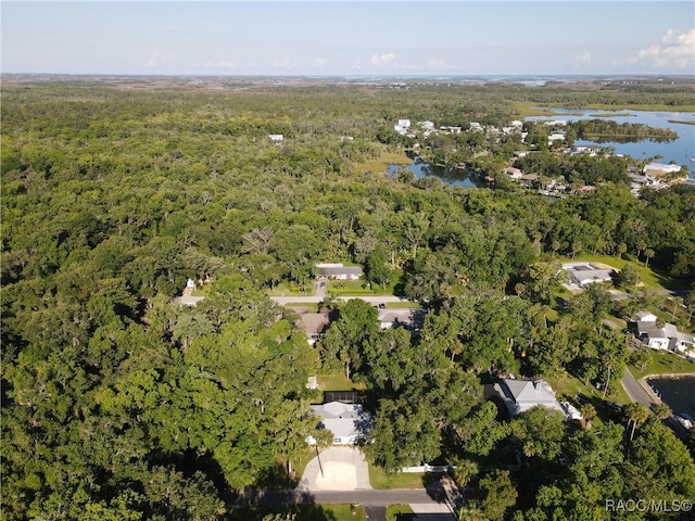 birds eye view of property featuring a water view and a wooded view