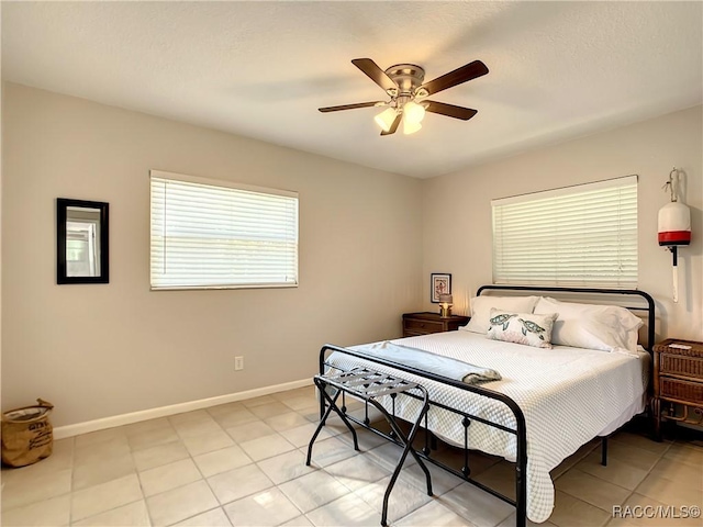 bedroom featuring ceiling fan, baseboards, and light tile patterned flooring