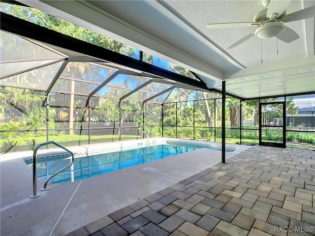 view of swimming pool featuring a patio, a lanai, and ceiling fan