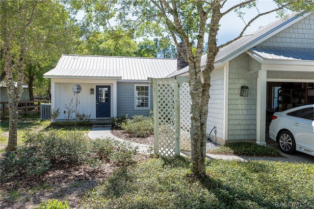 view of front of home with a chimney, metal roof, and an attached carport