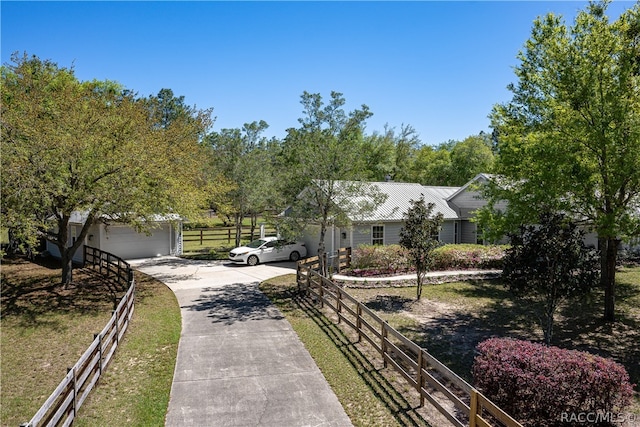 view of front of home with a garage, fence, and concrete driveway