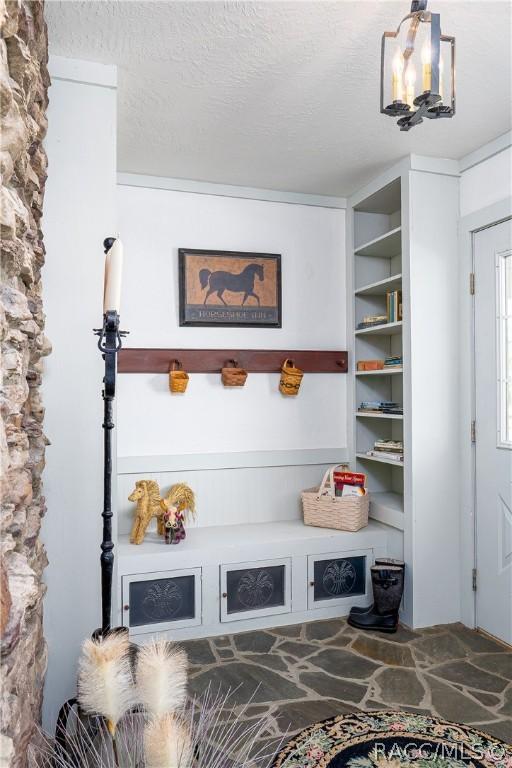 4210 W Horseshoe Dr, Beverly Hills, FL 34465 - mudroom with stone flooring, a chandelier, and a textured ceiling