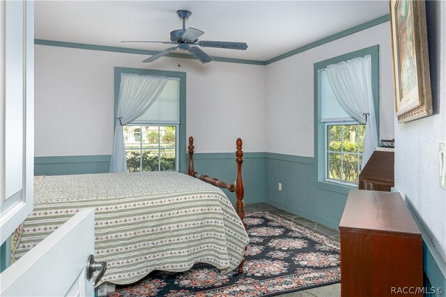 bedroom with a wainscoted wall, ceiling fan, and crown molding