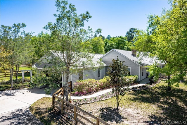 view of front of property with concrete driveway and fence