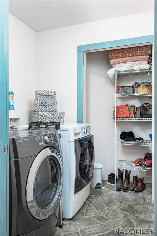 laundry area featuring stone finish flooring, independent washer and dryer, and laundry area