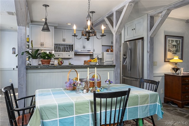 dining area featuring a chandelier and wainscoting