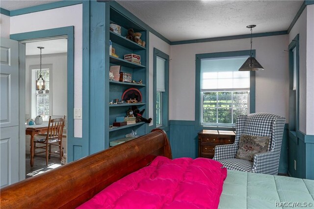 4210 W Horseshoe Dr, Beverly Hills, FL 34465 - bedroom featuring wainscoting, a textured ceiling, and crown molding