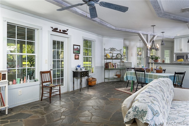 interior space featuring ceiling fan with notable chandelier