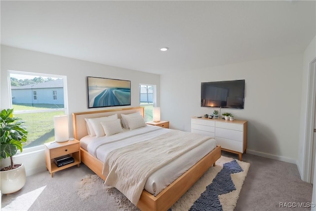 bedroom with light carpet, recessed lighting, and baseboards